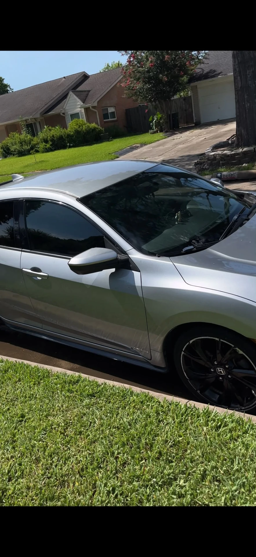 Silver Honda Civic detailed and gloss-finished in a Houston driveway